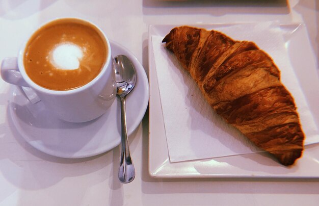 Close-up of coffee and cappuccino served on table