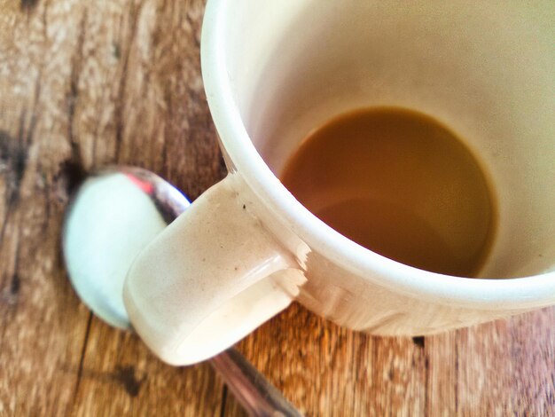 Foto close-up di una tazza di caffè con un cucchiaio sul tavolo