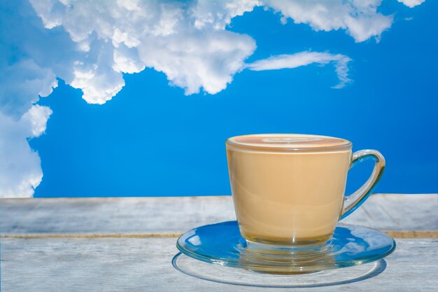 Close-up of coffee cup on table against blue sky
