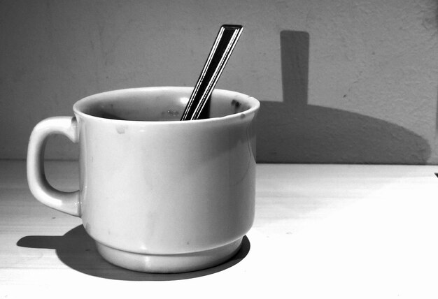 Close-up of coffee cup on table against wall