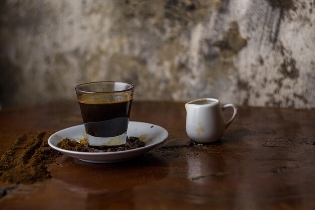 Foto close-up di una tazza di caffè sul tavolo contro la parete