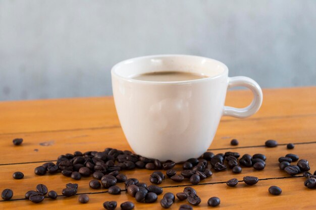 Close-up of coffee cup with roasted beans on table