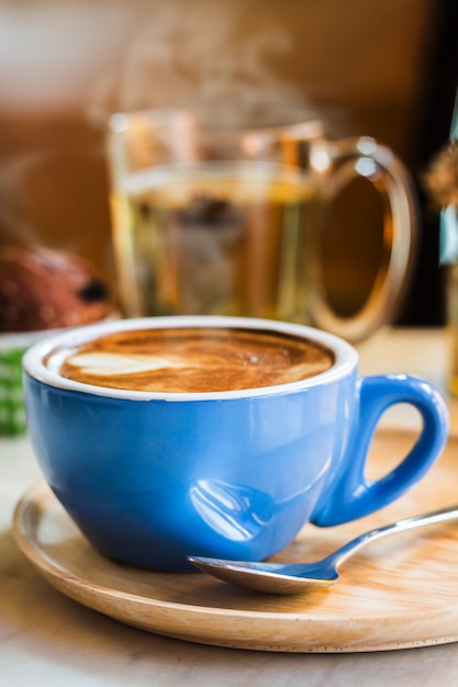 Foto chiuda sulla tazza di caffè con vapore sulla tavola in caffè.