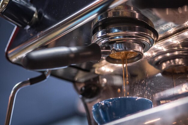 Close-up of coffee falling in cup at cafe