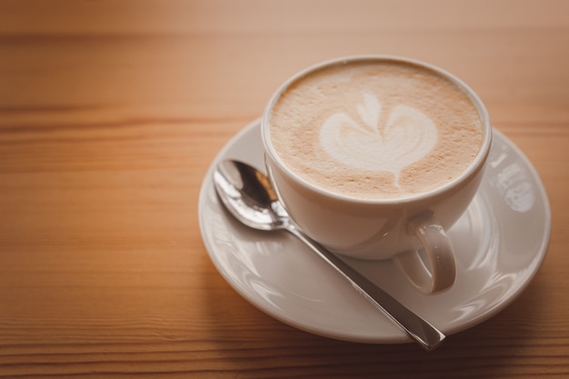 Foto primo piano di un caffè latte su un pavimento di legno.