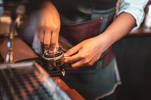 Close-up coffee maker that is professionally extracting coffee by barista with a deep white glass in the evening sun light. coffee, extraction, deep, machine, make, barista concept.