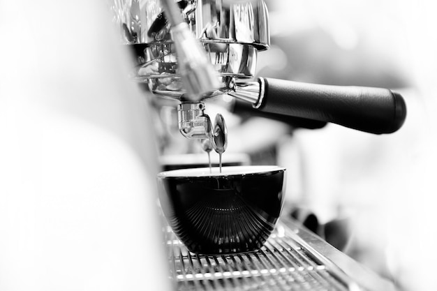 Foto close-up del caffè che scorre dal rubinetto