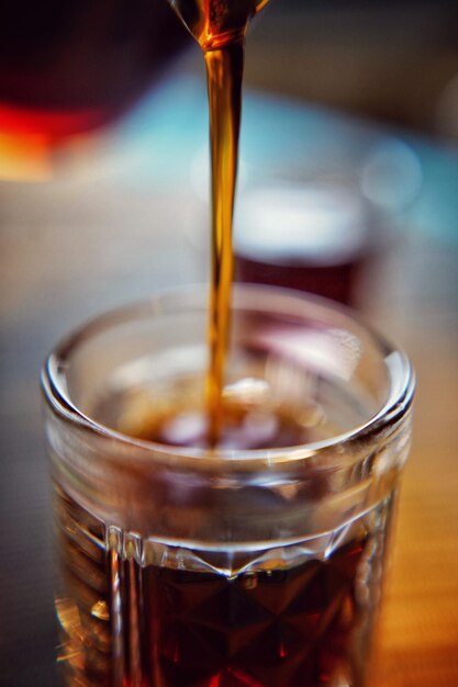 Close-up of coffee pouring in glass