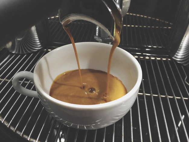 Photo close-up of coffee pouring into cup