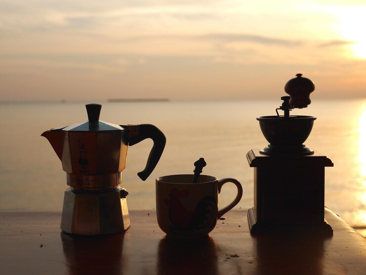 Photo close-up of coffee on table against sea during sunset