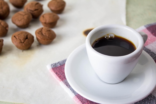Close-up of coffee with muffins on table