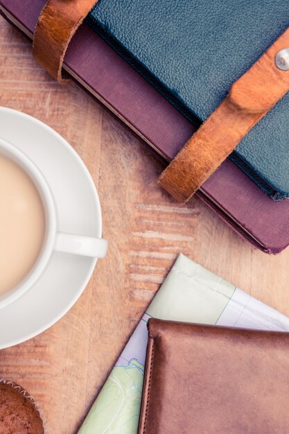 Close-up of coffee with wallet and diaries on table