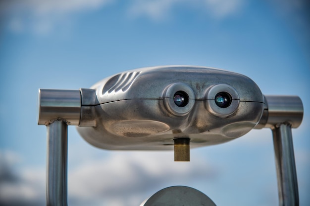 Photo close-up of coin-operated binoculars against sky