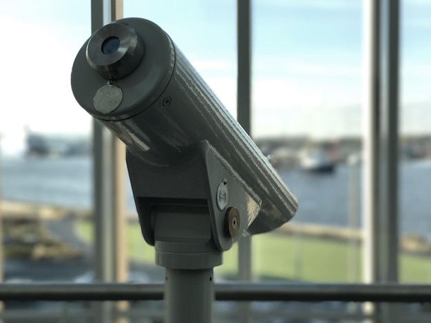 Photo close-up of coin-operated binoculars against sky