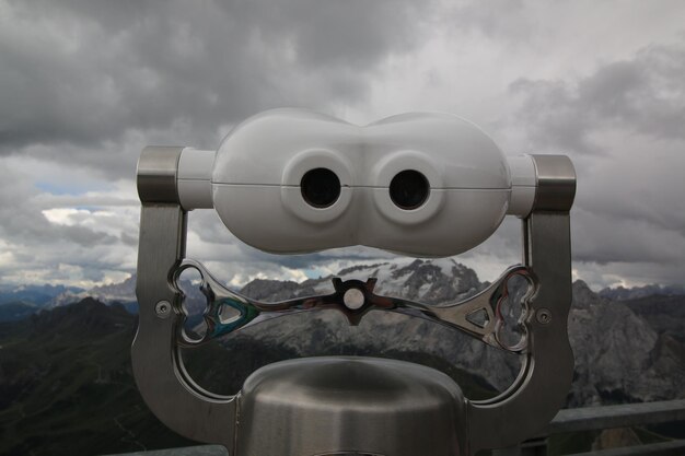 Photo close-up of coin-operated binoculars against sky