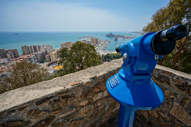 Foto close-up di binocoli a monete sul mare e sul paesaggio urbano