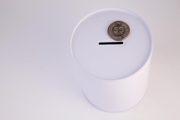 Photo close-up of coin on piggy bank over white background