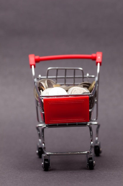 Photo close-up of coins in cart on table