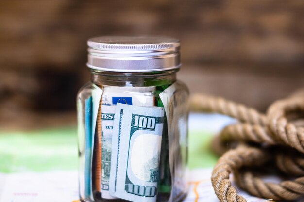 Photo close-up of coins in jar on table