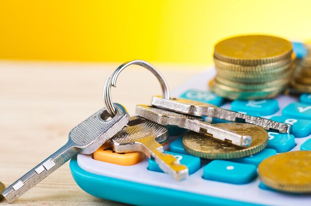 Close-up of coins and keys on calculator