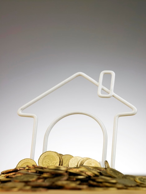 Photo close-up of coins and model home against gray background