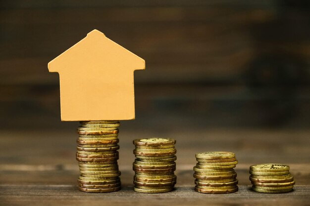 Photo close-up of coins and model home on table