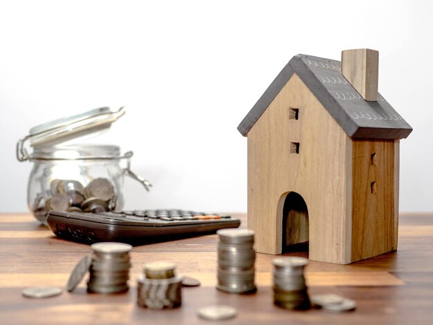 Photo close-up of coins and model house on table