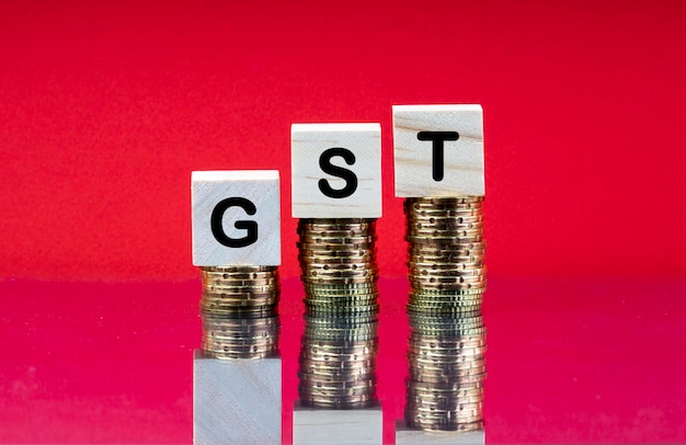 Close-up of coins with gst on table against red background