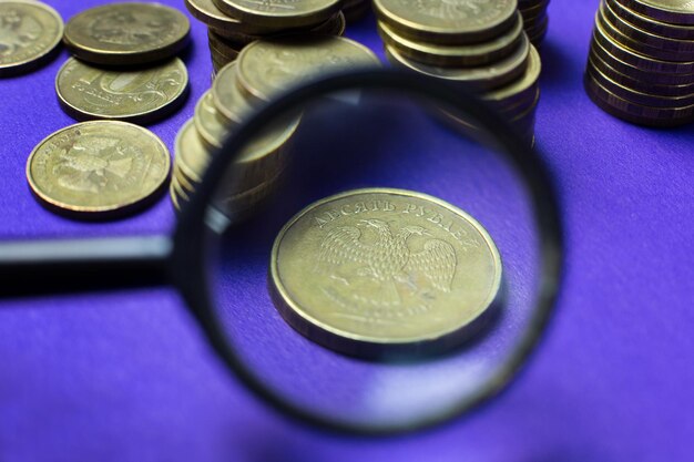 Close-up of coins with magnifying glass on table
