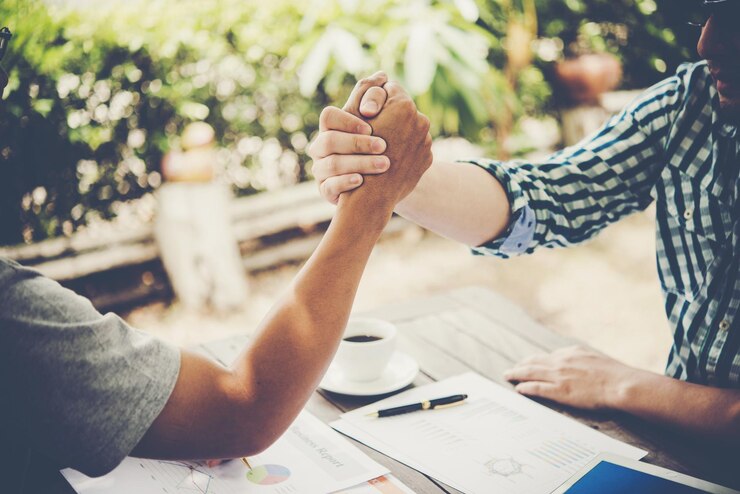Photo close-up of colleagues arm wrestling at table