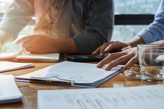 Close-up of colleagues working on table in office