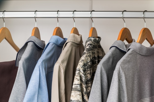 Close up collection Hangers with clothes on rack in wardrobe