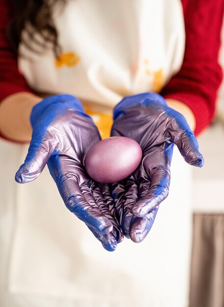 Близкий взгляд на цветное пасхальное яйцо в руках