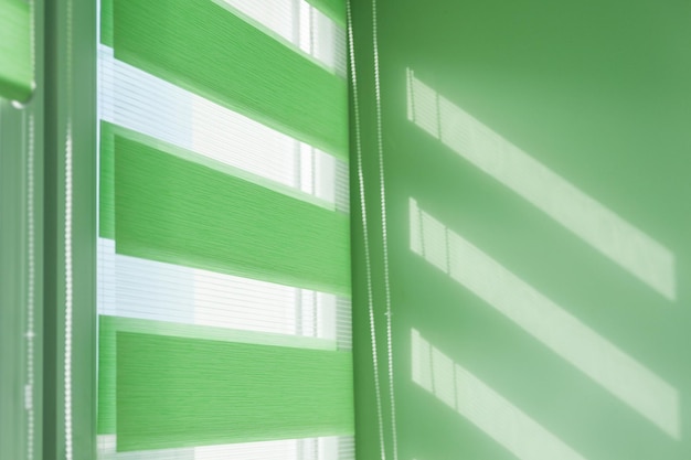 Close up of colored fabric roller blinds on window. Roll curtains.