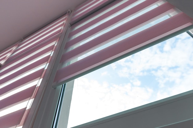 Close up of colored fabric roller blinds on window. Roll curtains.