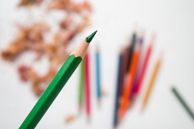 Foto close-up di una matita colorata con il coperchio rotto su uno sfondo bianco