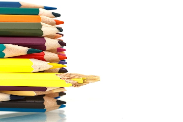 Close-up of colored pencils on table against white background