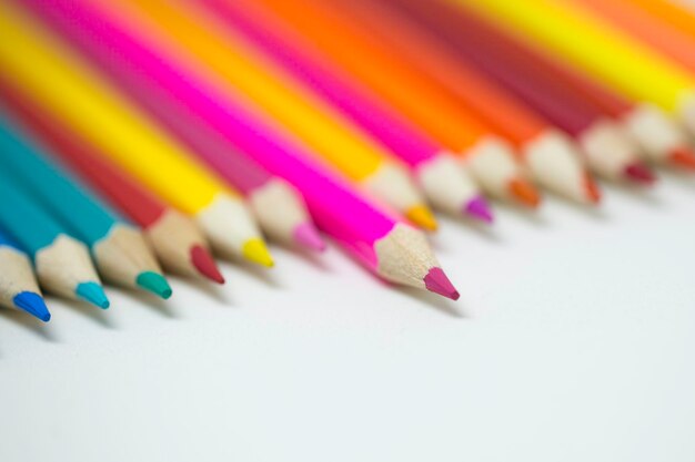 Close-up of colored pencils over white background