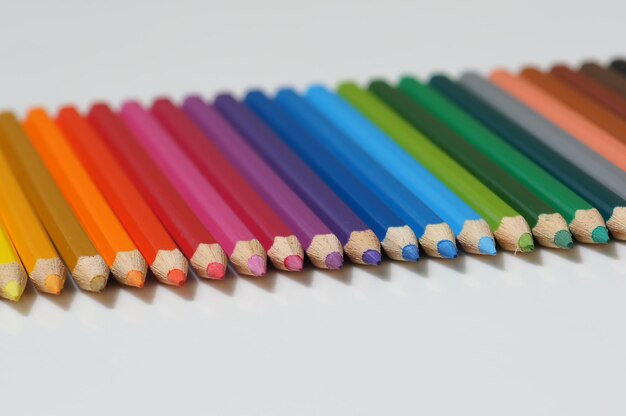 Close-up of colored pencils over white background