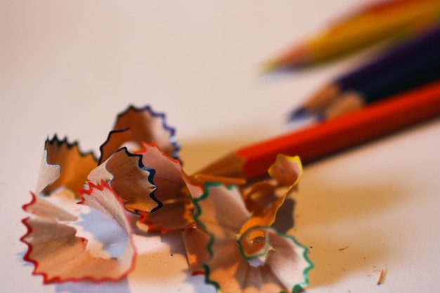 Photo close-up of colored pencils with shavings on table