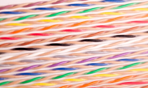 Close-up colored wires lie next to each other on a white table during the production of super computers and office equipment. Concept for the production of smartphones and tablets. Advertising space