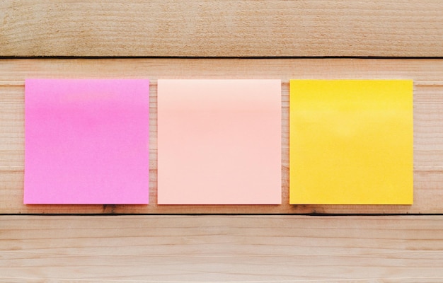 Photo close-up of colorful adhesive notes on wooden wall