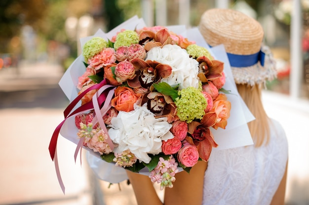 Close up of a colorful bouquet in the hands of a girl no face