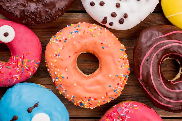 Close up of colorful donuts background. Assorted donuts with sprinkles. Freshly baked pastry.