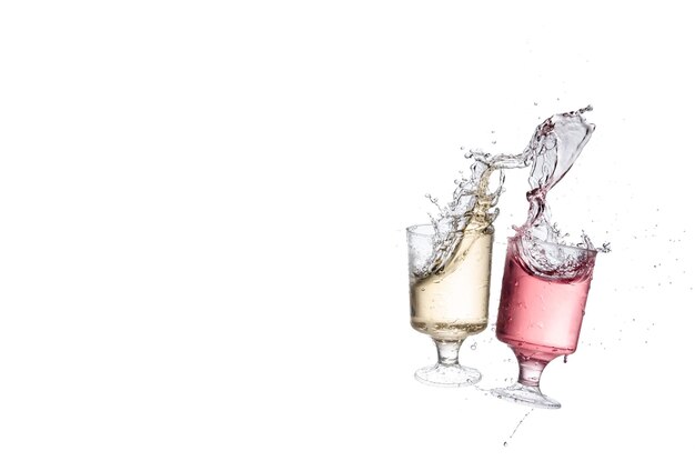 Photo close-up of colorful drinks splashing against white background