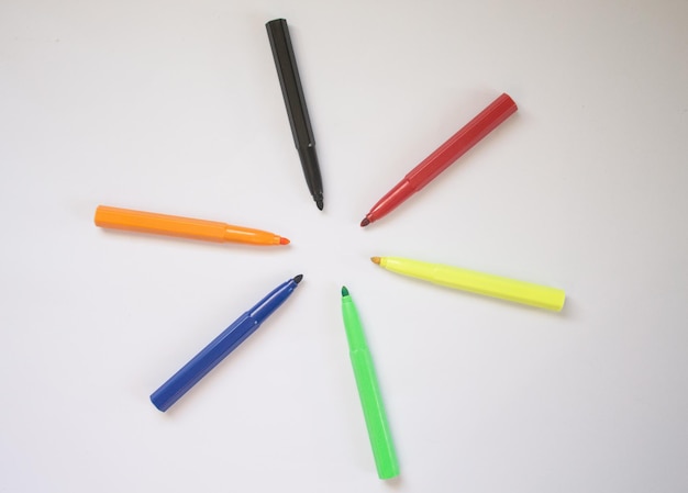 close-up of colorful felt tip pens arranged over white background