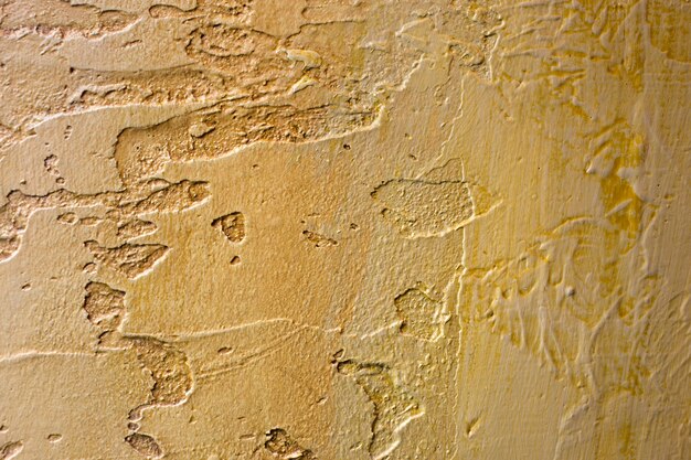 Foto primo piano della parete irregolare dello stucco irregolare intonacata bronzo dorato.