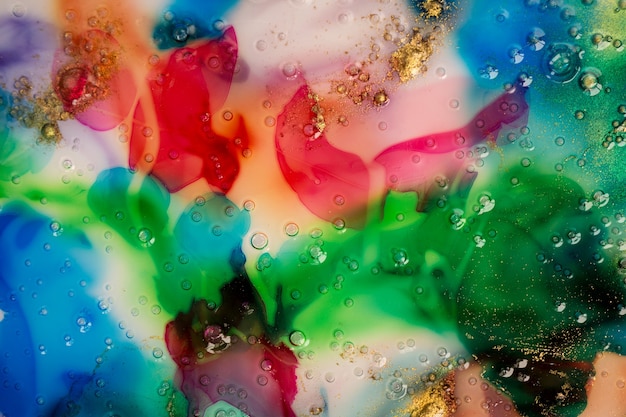 Close up colorful ink stains background liquid transparent bubbles texture with gold glitter