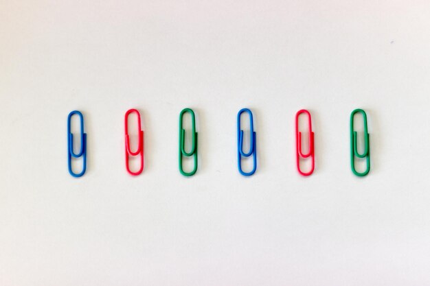 Photo close-up of colorful paper clips over white background