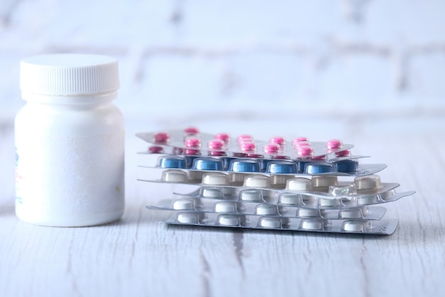 Close up of colorful pills spilling on white background